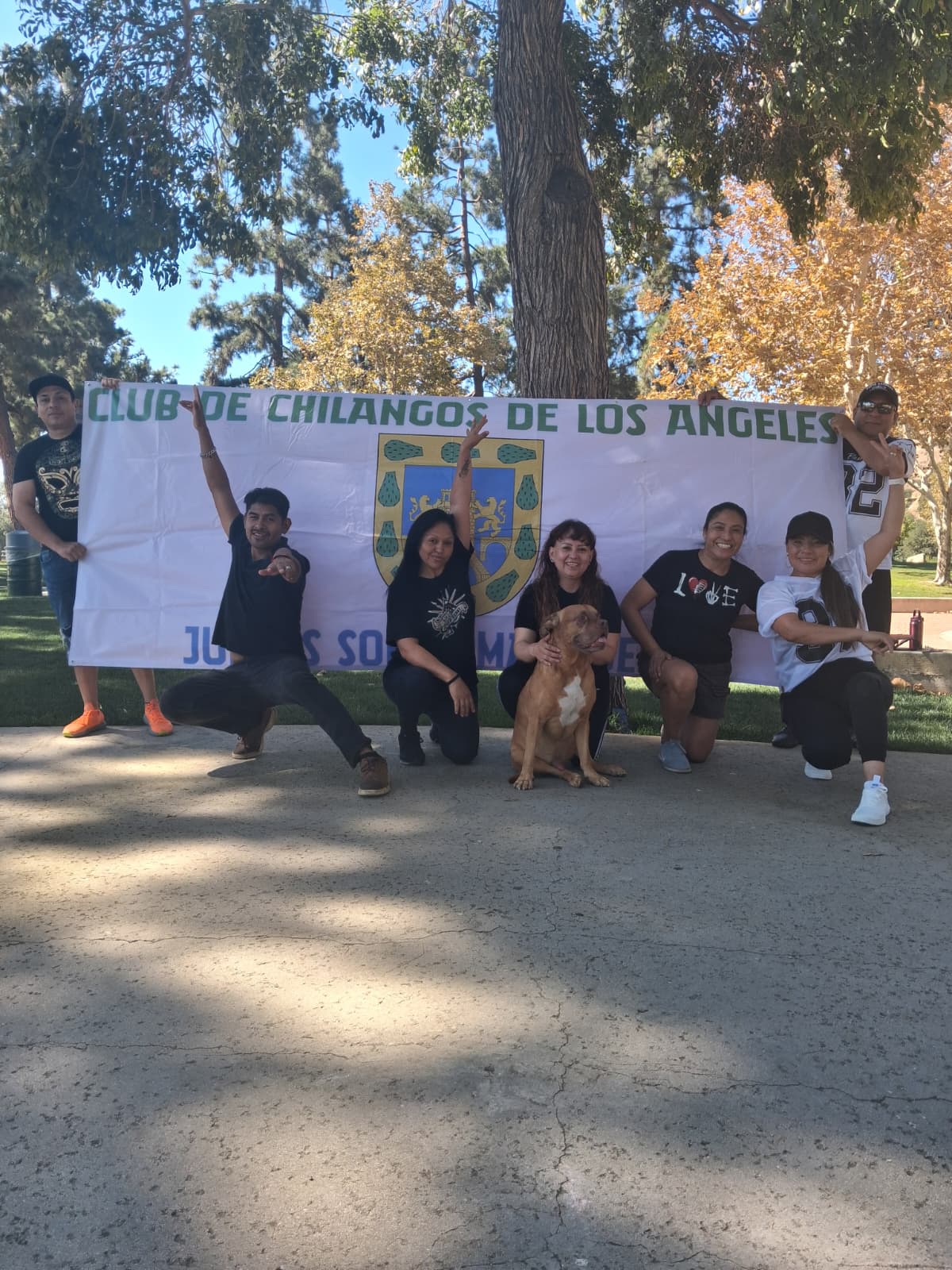 Integrantes del Club de Chilangos de Los Ángeles con la lona del club
